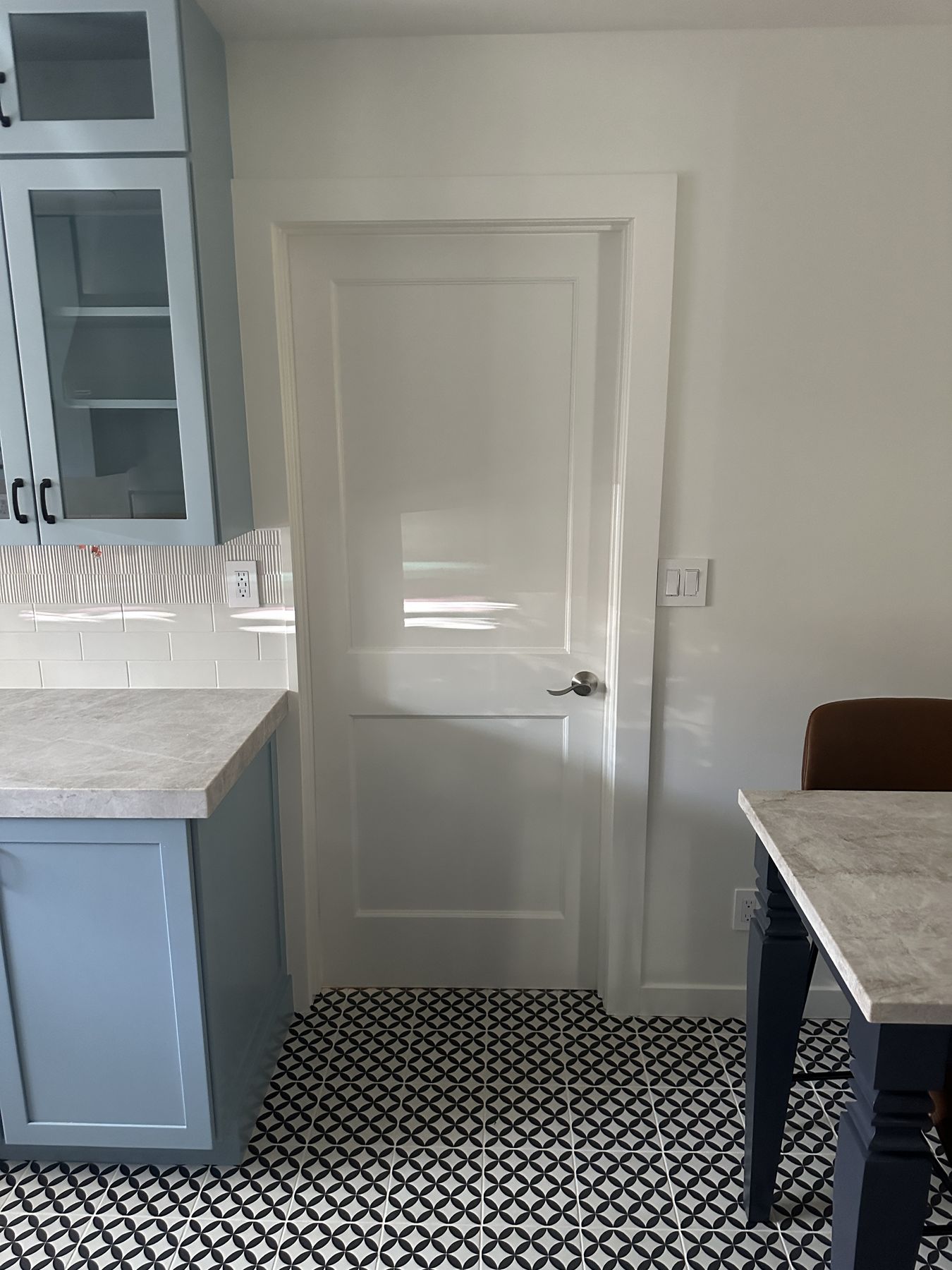 Two-panel door and casing trim next to the cabinets