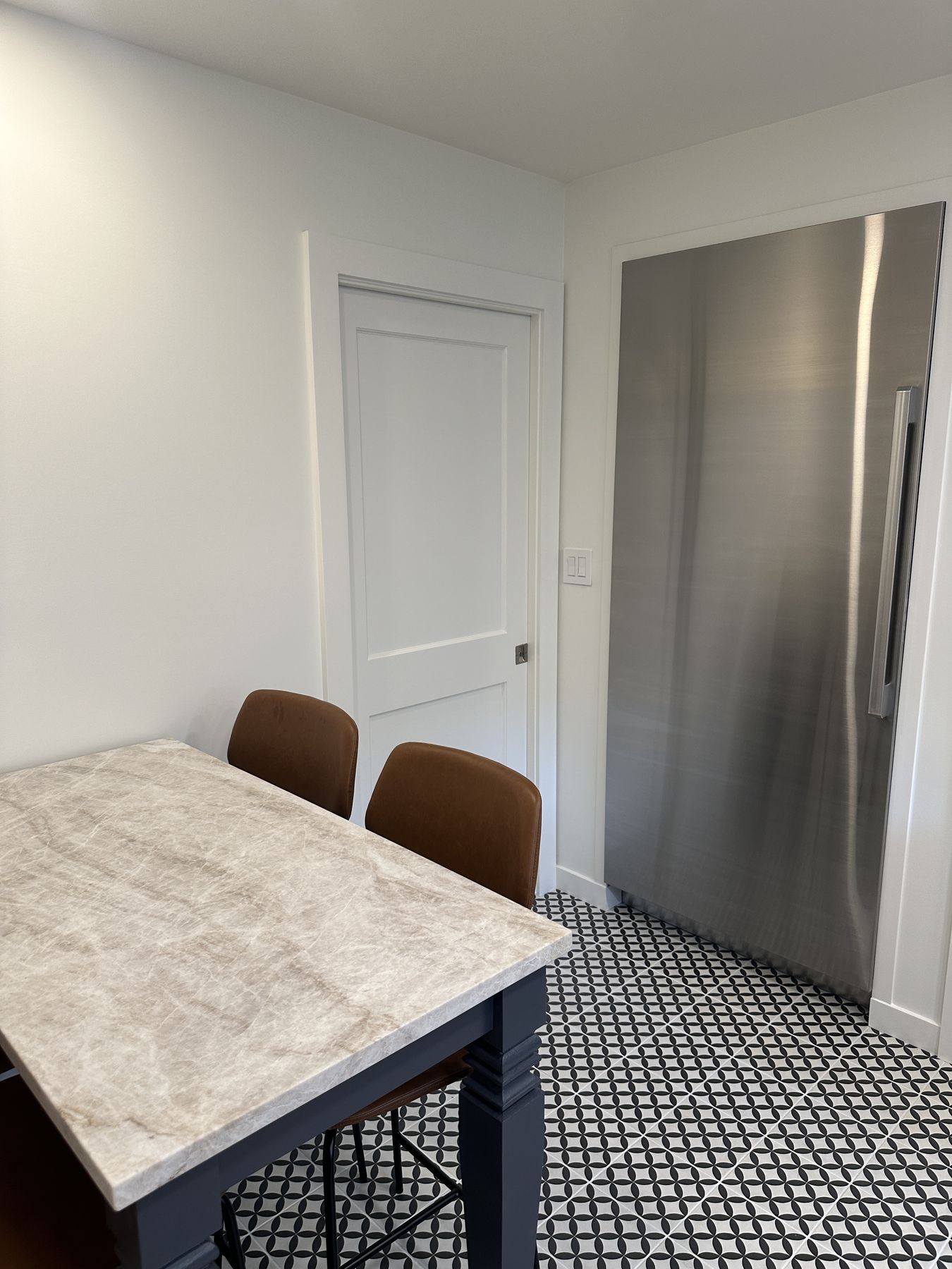 Full-size refrigerator set flush into the wall next to the eating area