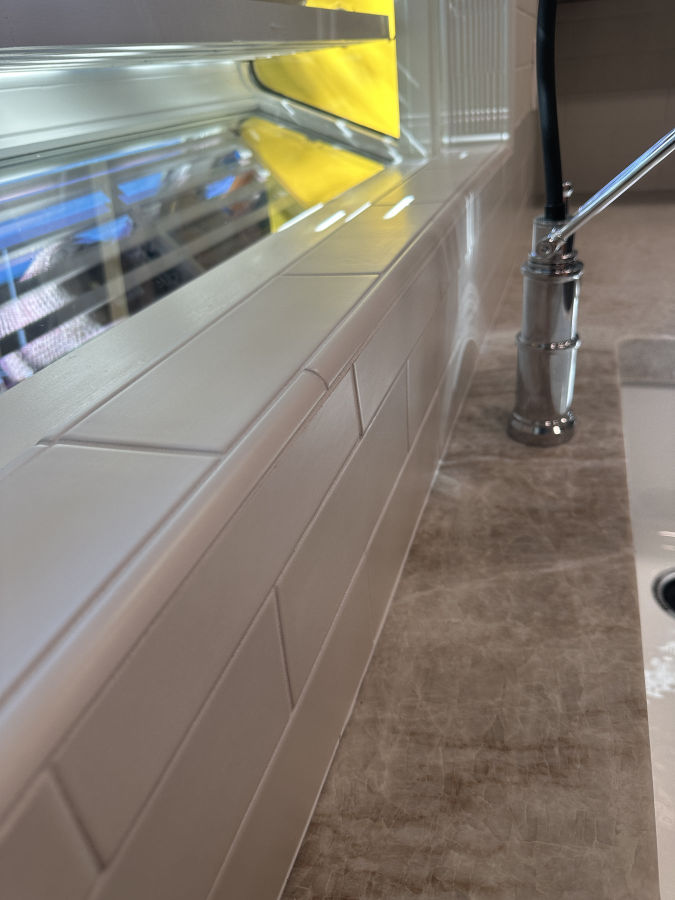 Subway tile with bullnose trim at the garden window sill